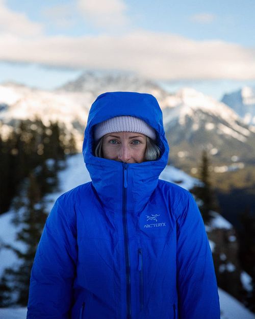 Marie-Christine Huot standing on top of a mountain wearing a parka