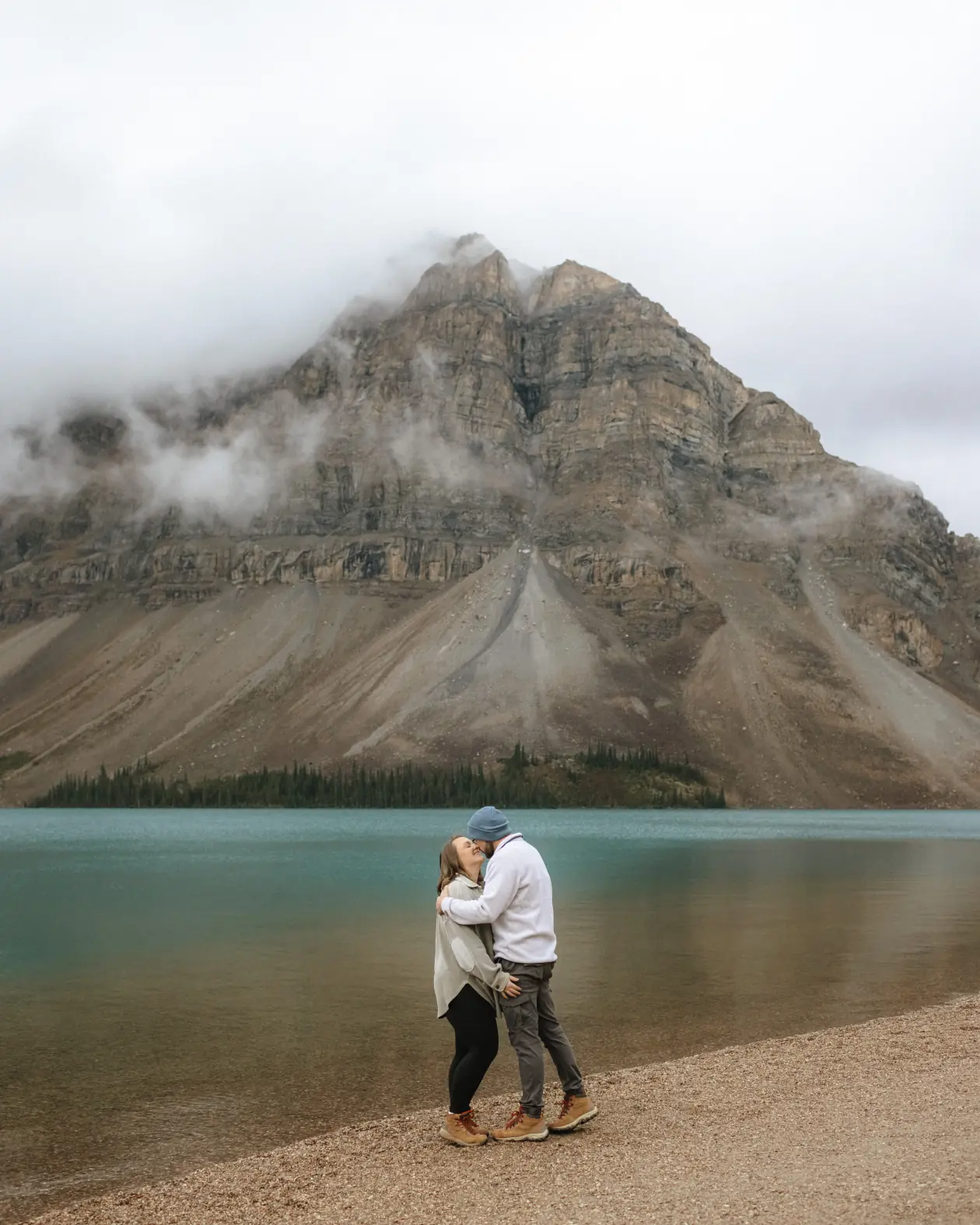 Couple standing in front of a mountain at Bow Lake