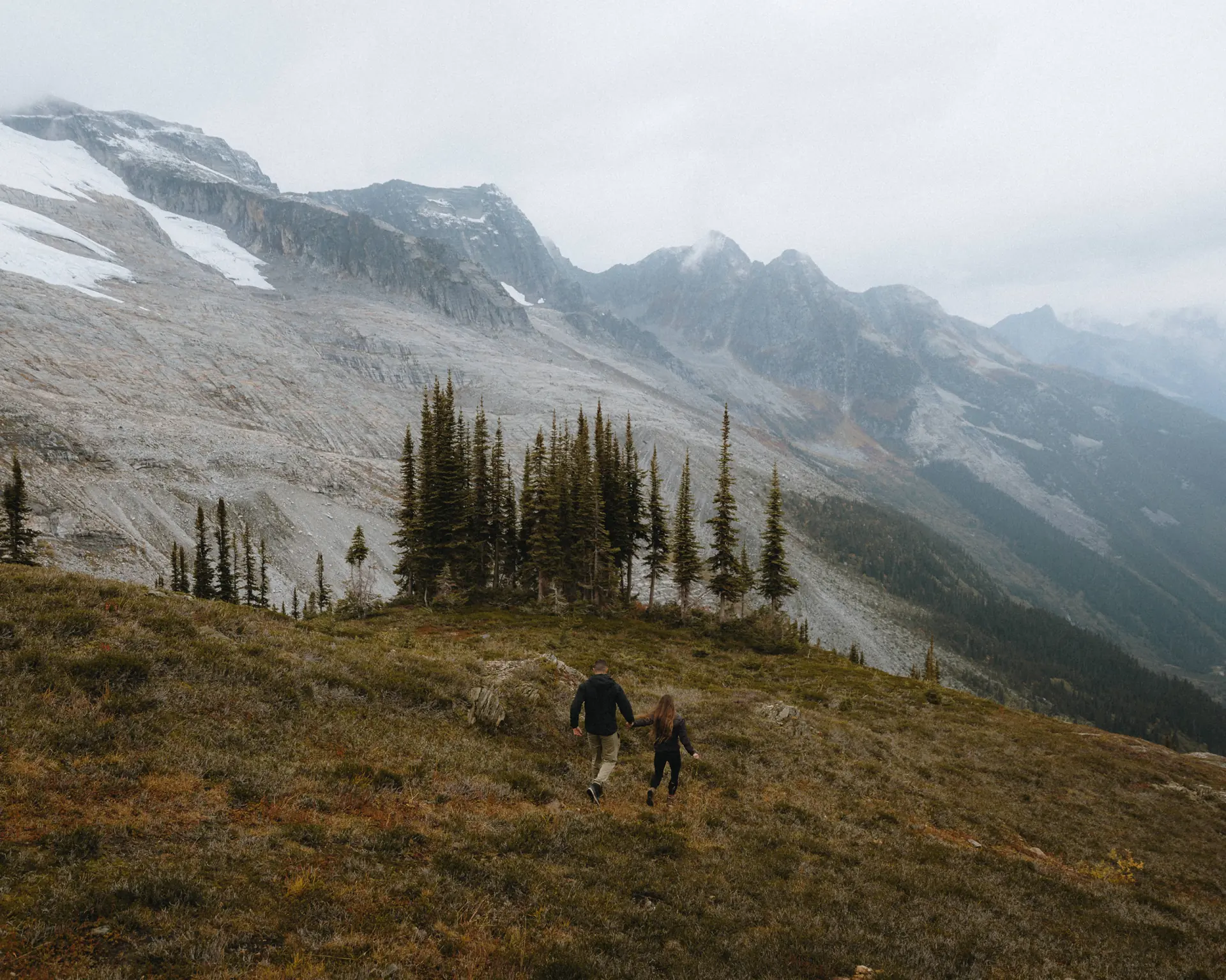 couple running in the meadows high in the mountains