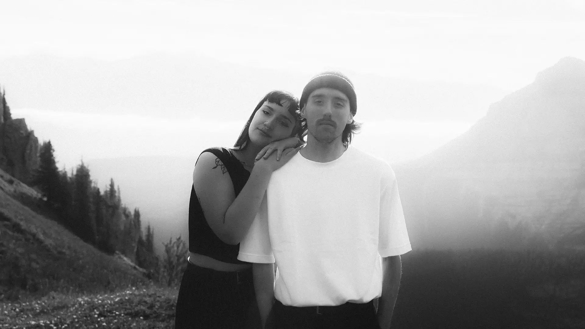 Intimate black and white portrait of couple embracing in Kananaskis wilderness during soft light photography session