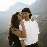Candid kiss on the cheek during a Banff couples adventure session in the Canadian Rockies.