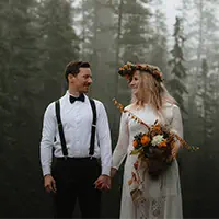 Newlyweds laugh together in misty forest of Yoho National Park near Banff and Lake Louise