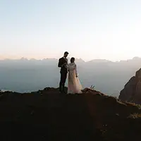 Silhouetted couple on mountain ridge at sunset