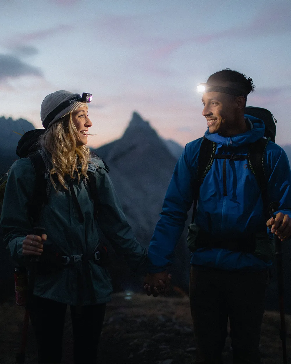 Couple in hiking gear sharing moment at sunrise during adventurous Kananaskis mountain engagement