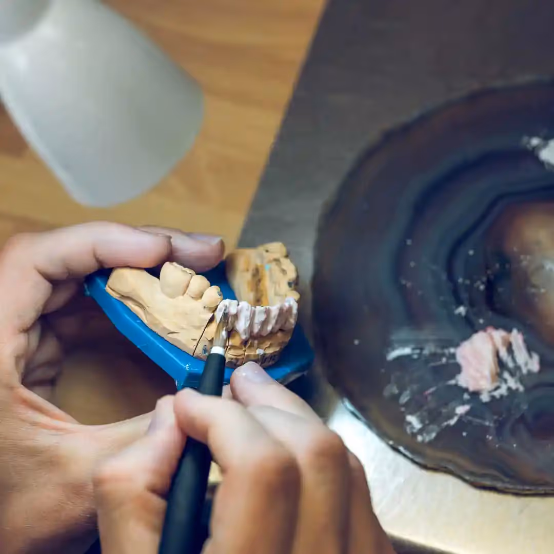 Material being added to a base of a denture.