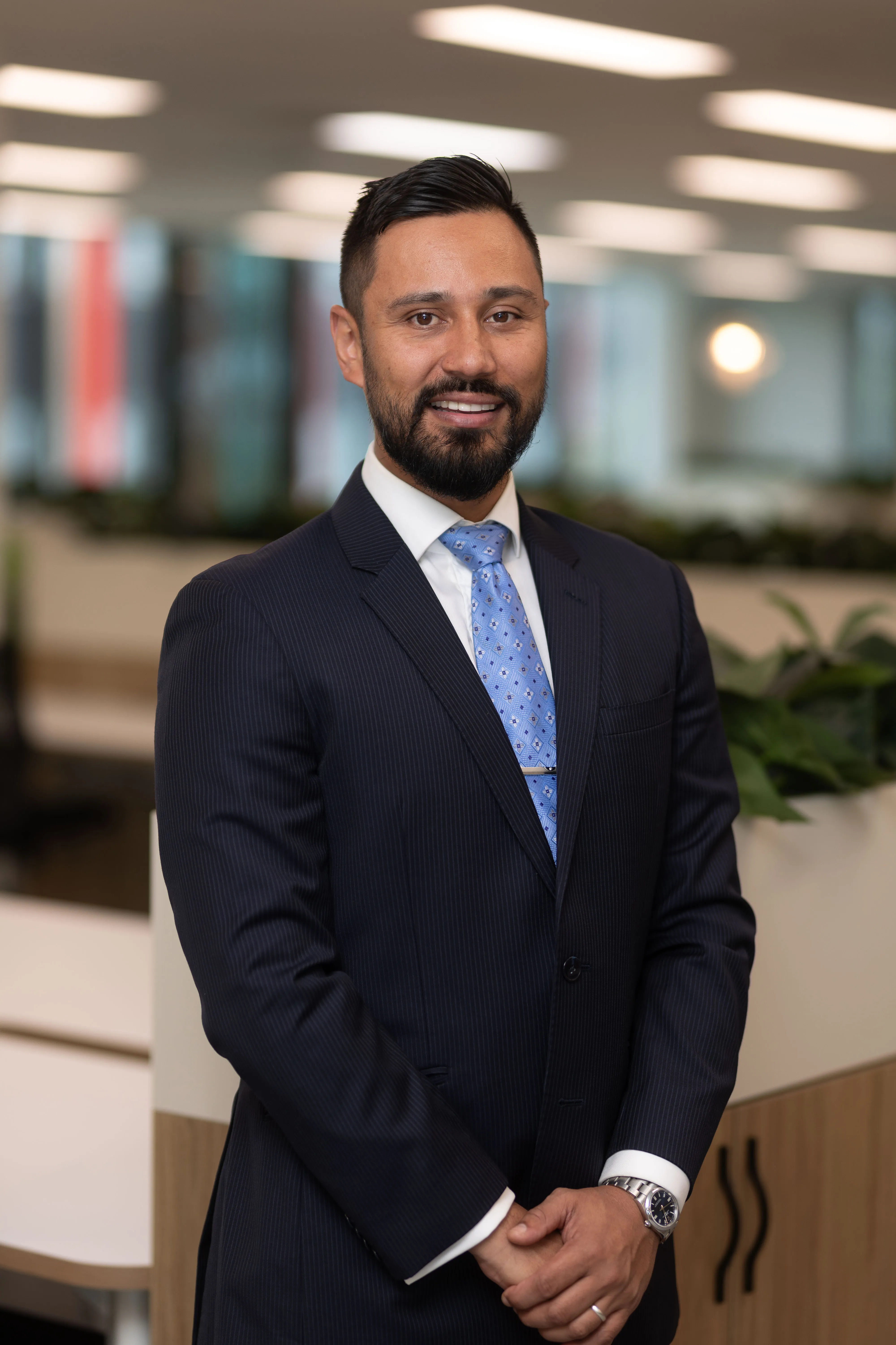 A man in a suit and tie standing in an office.