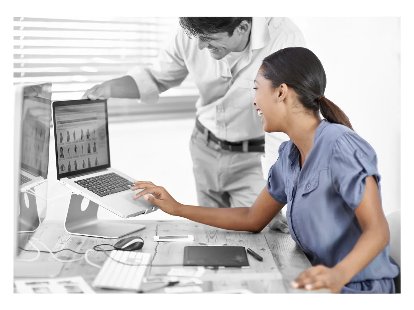 A woman sitting at a desk using a laptop computer.