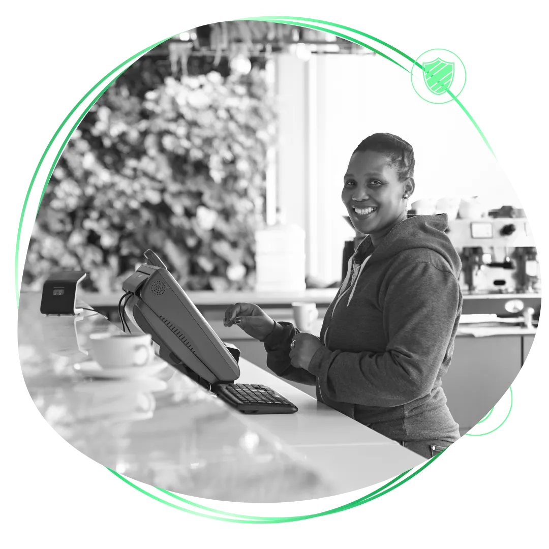 A black and white photo of a woman using a laptop.