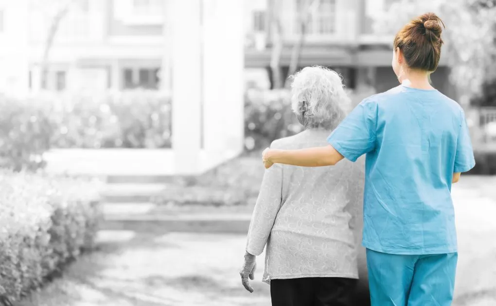 A black and white photo of an elderly woman and a nurse.