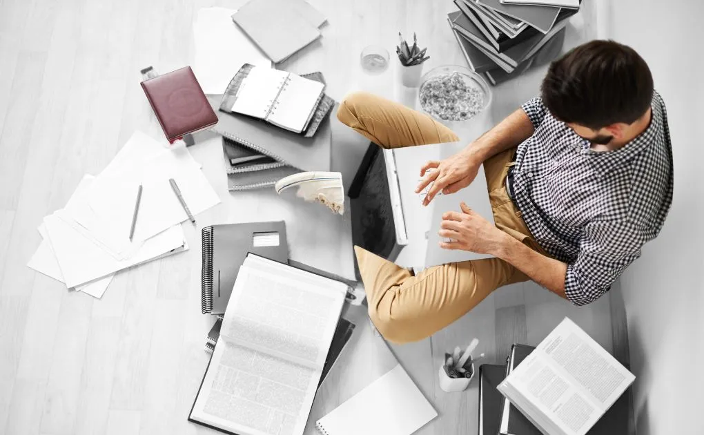 A man sitting on the floor with a laptop.