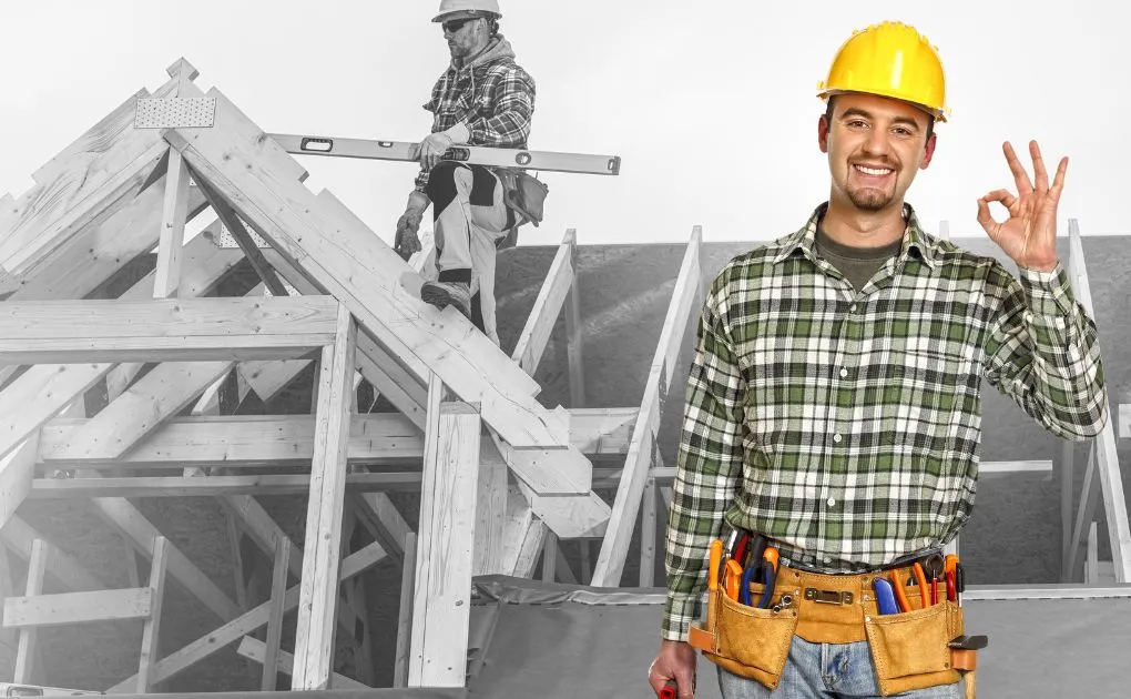 A man wearing a hard hat standing in front of a construction site.
