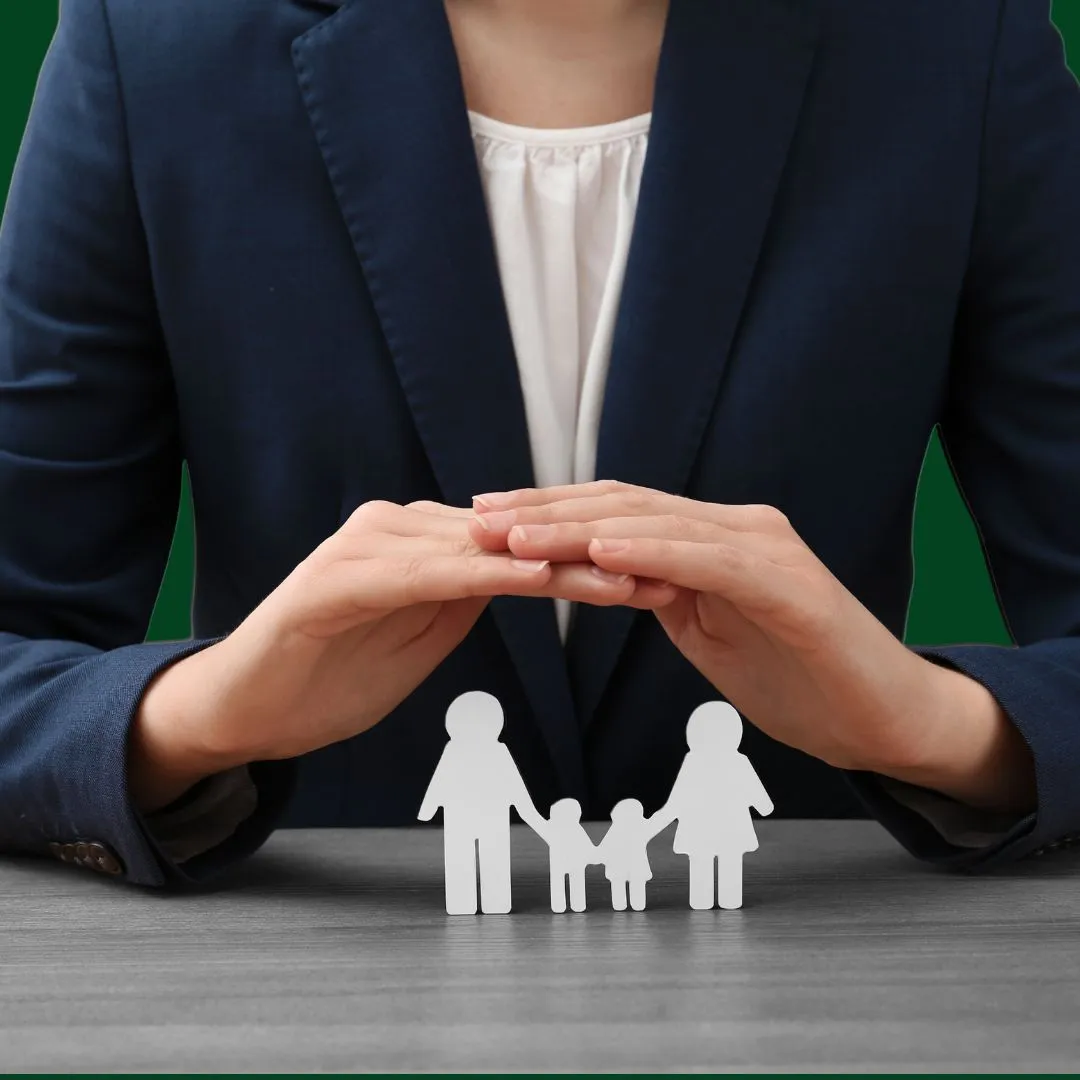 A woman holding a cutout of a family.