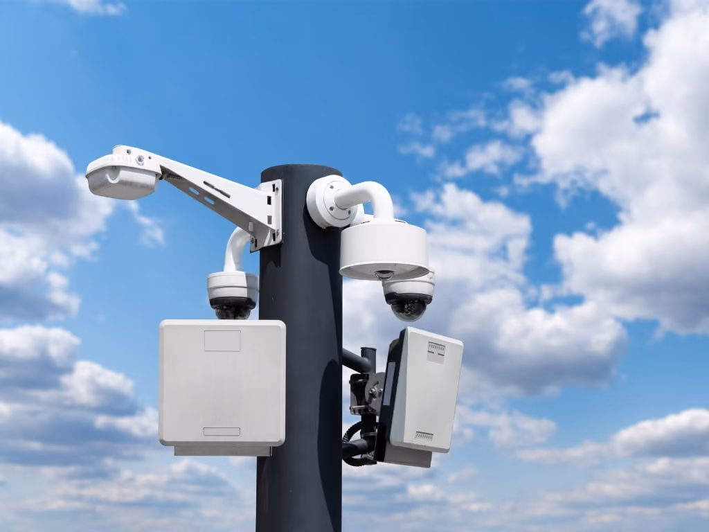 security cameras on a post with antennas for wireless backhaul against a blue sky