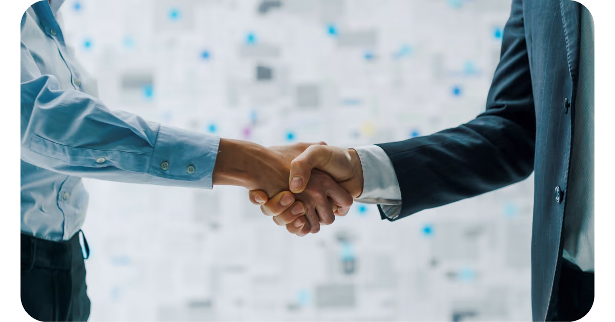 Two business people shaking hands in front of a white background