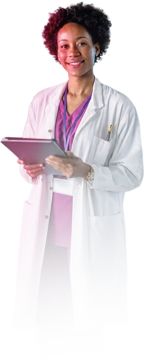 Smiling medical professional in purple scrubs and white coat holding a tablet with a pen in her pocket.