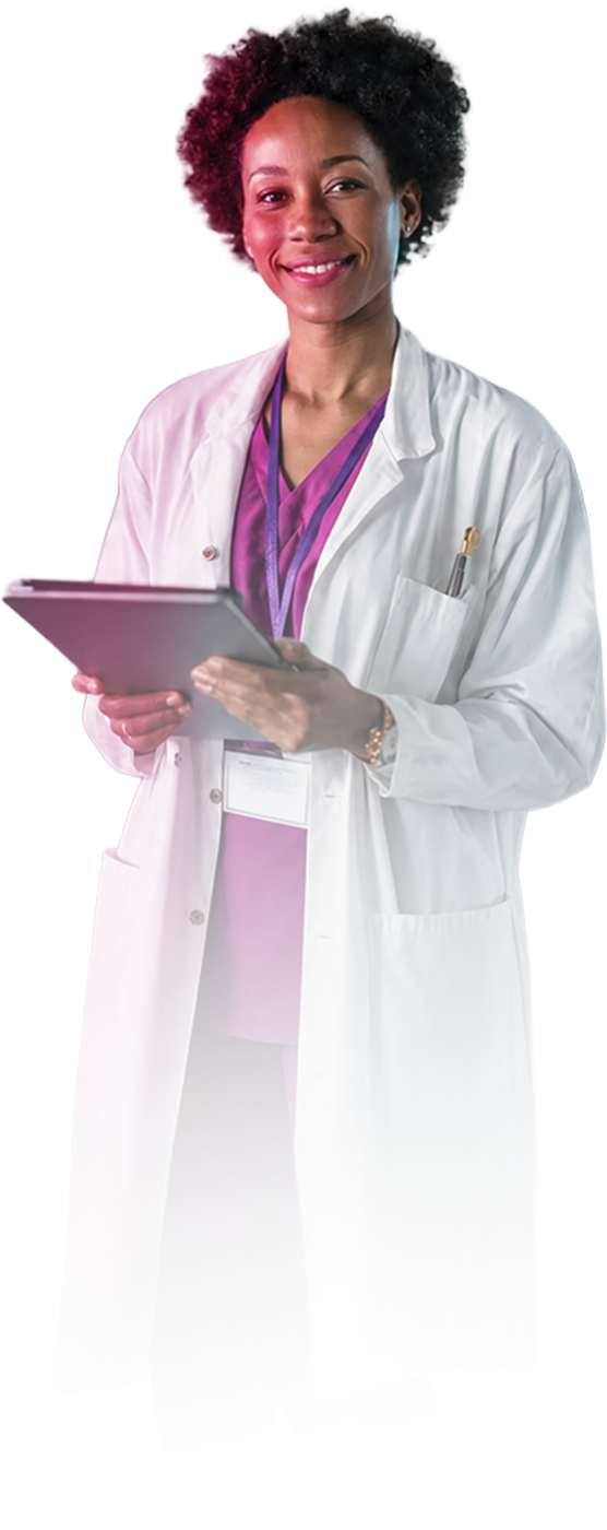 Smiling medical professional in purple scrubs and white coat holding a tablet with a pen in her pocket.