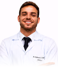 Smiling male doctor wearing a white coat and black tie against a white background.