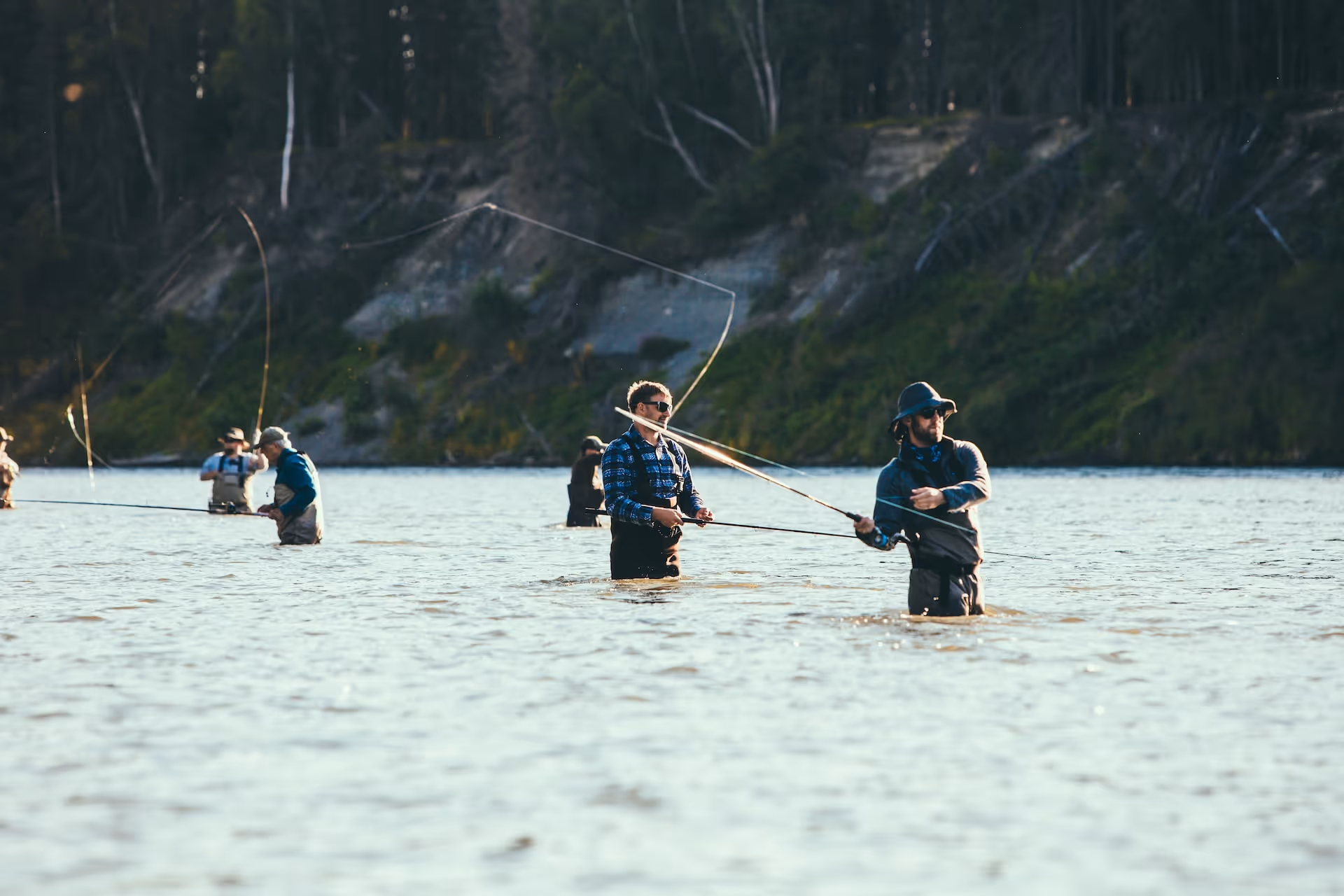 Groep van mensen die in het water staan en een het vliegvissen of casten zijn 