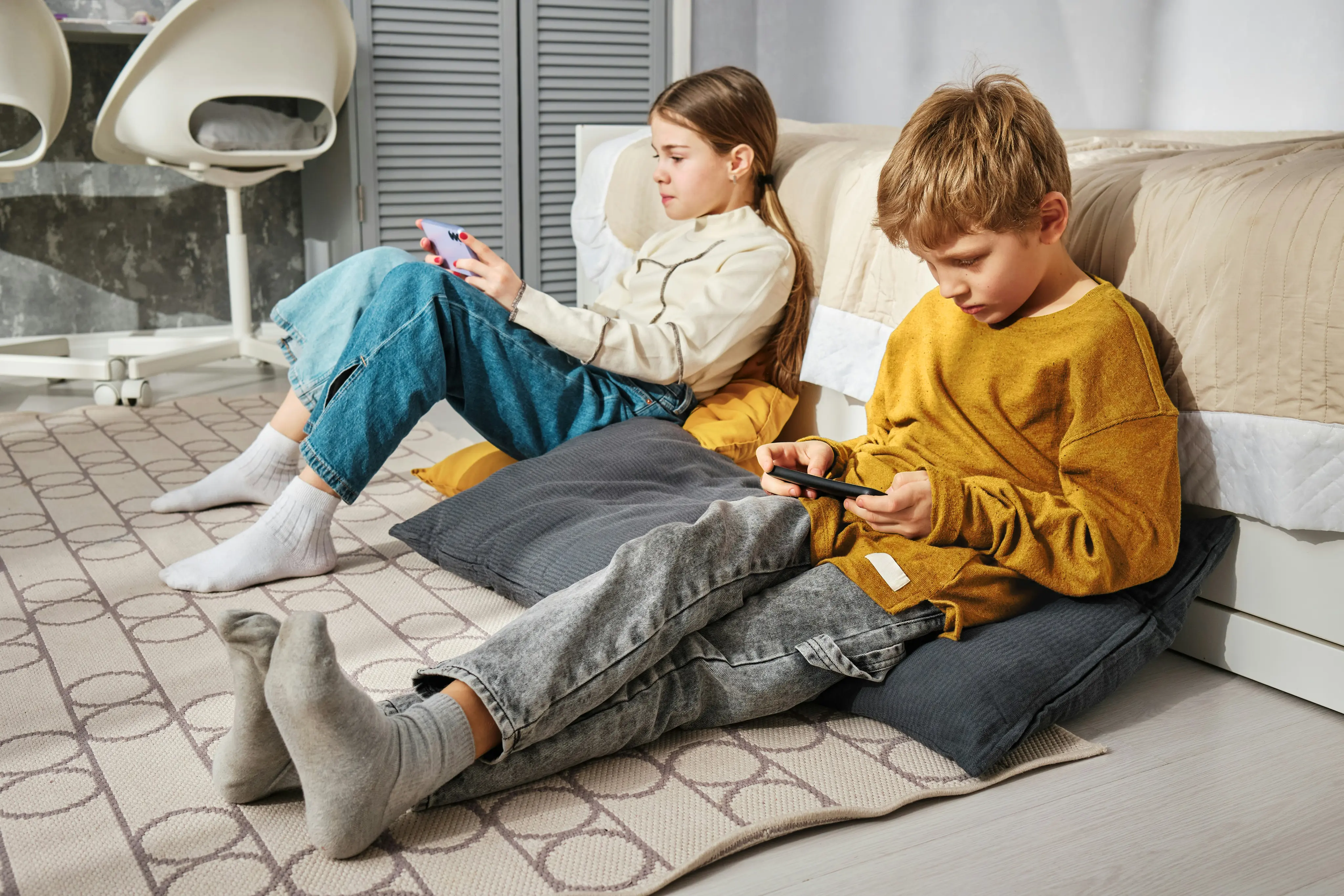 A boy and a girl are playing games on their phones.