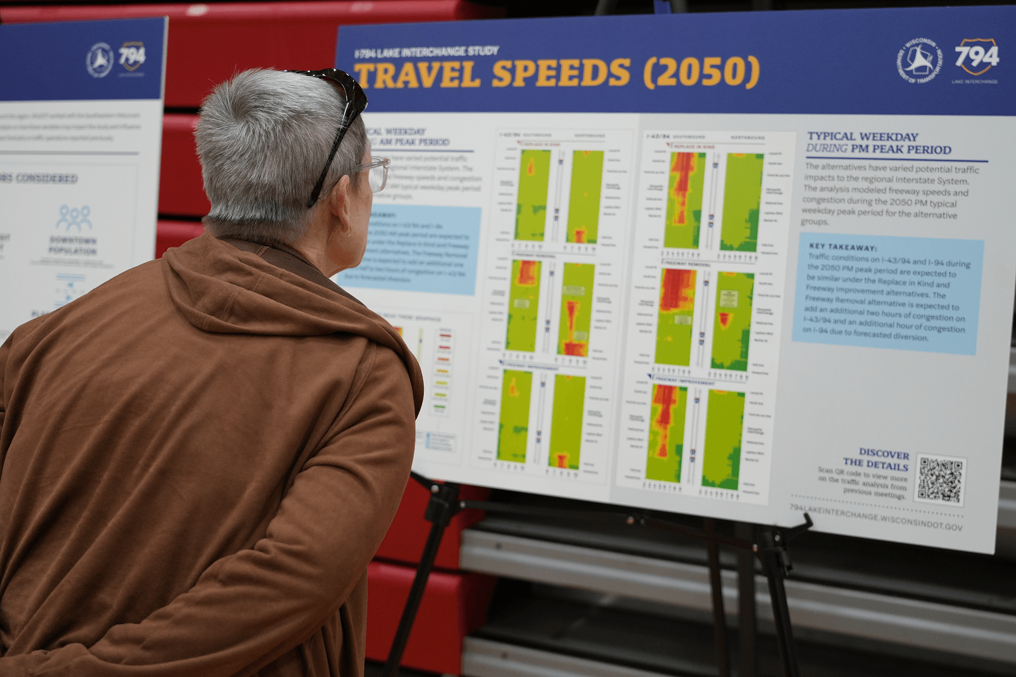 A community member reading a Public Involvement Meeting board on Travel Speeds (2050).
