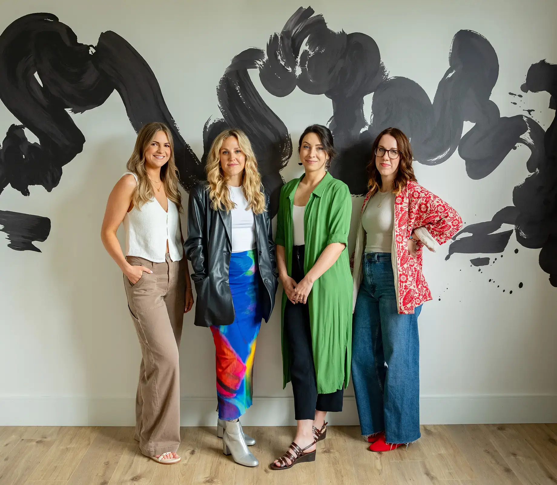 Bricks and Birches Interior Design Team posing for group photo in front of mural.