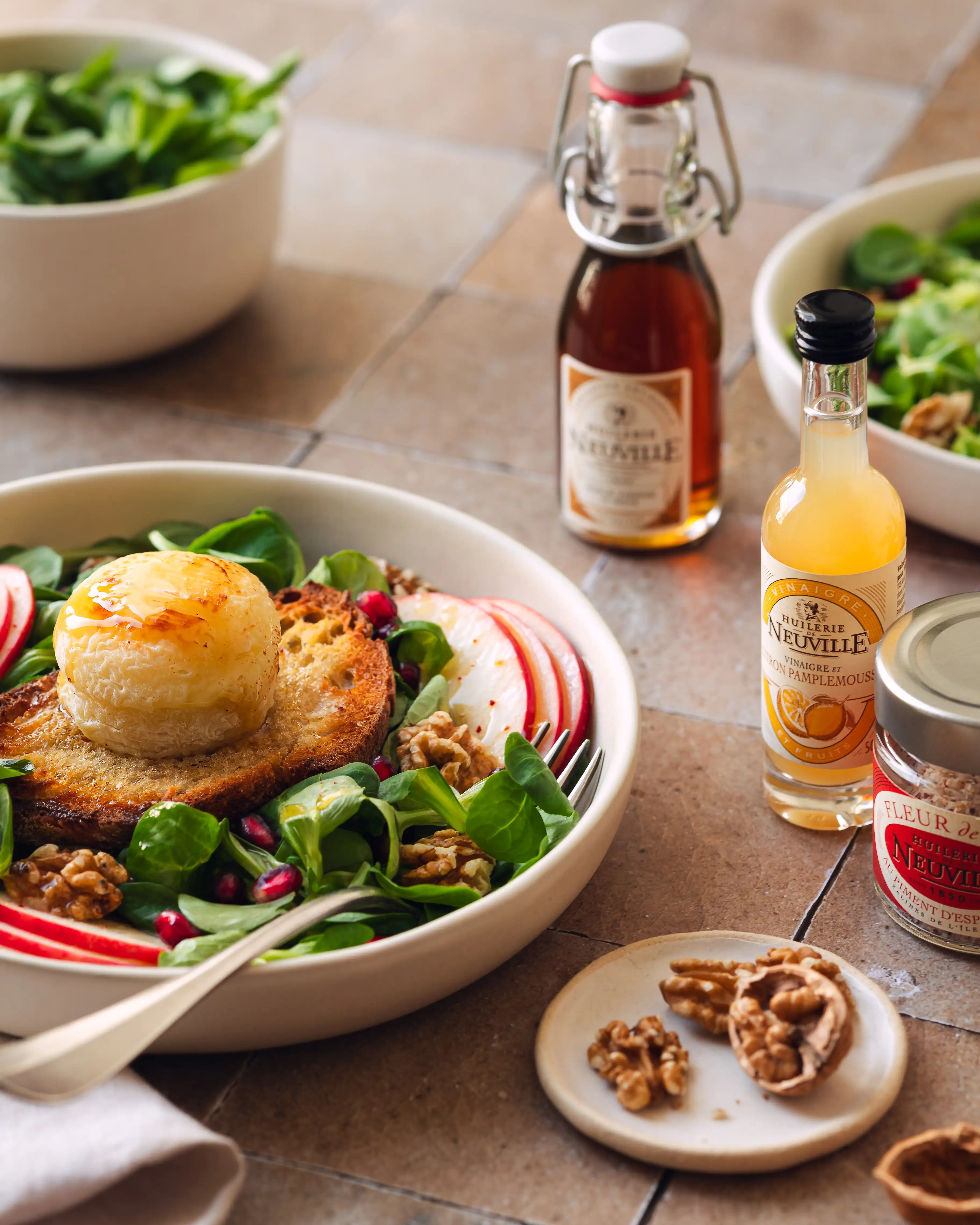 Salade composée et produits Huilerie de Neuville sur du carrelage beige