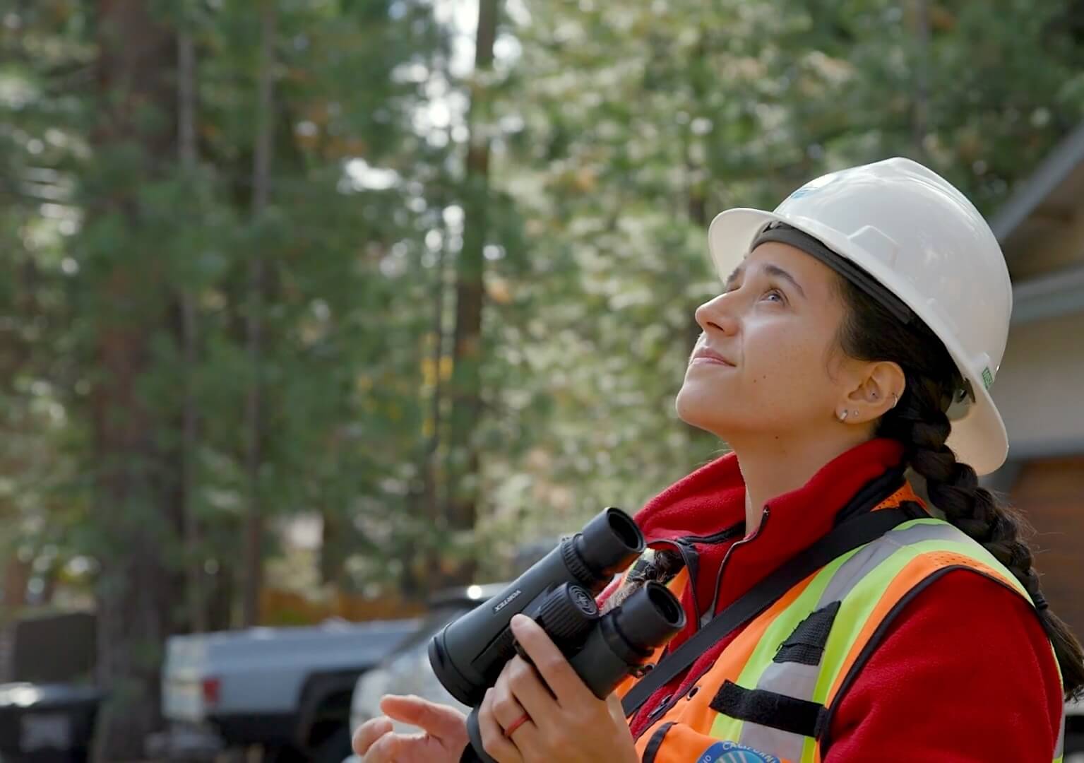 Safety officer inspects power lines with binoculars