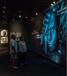 Two people looking at a screen of our eyes inside the museum