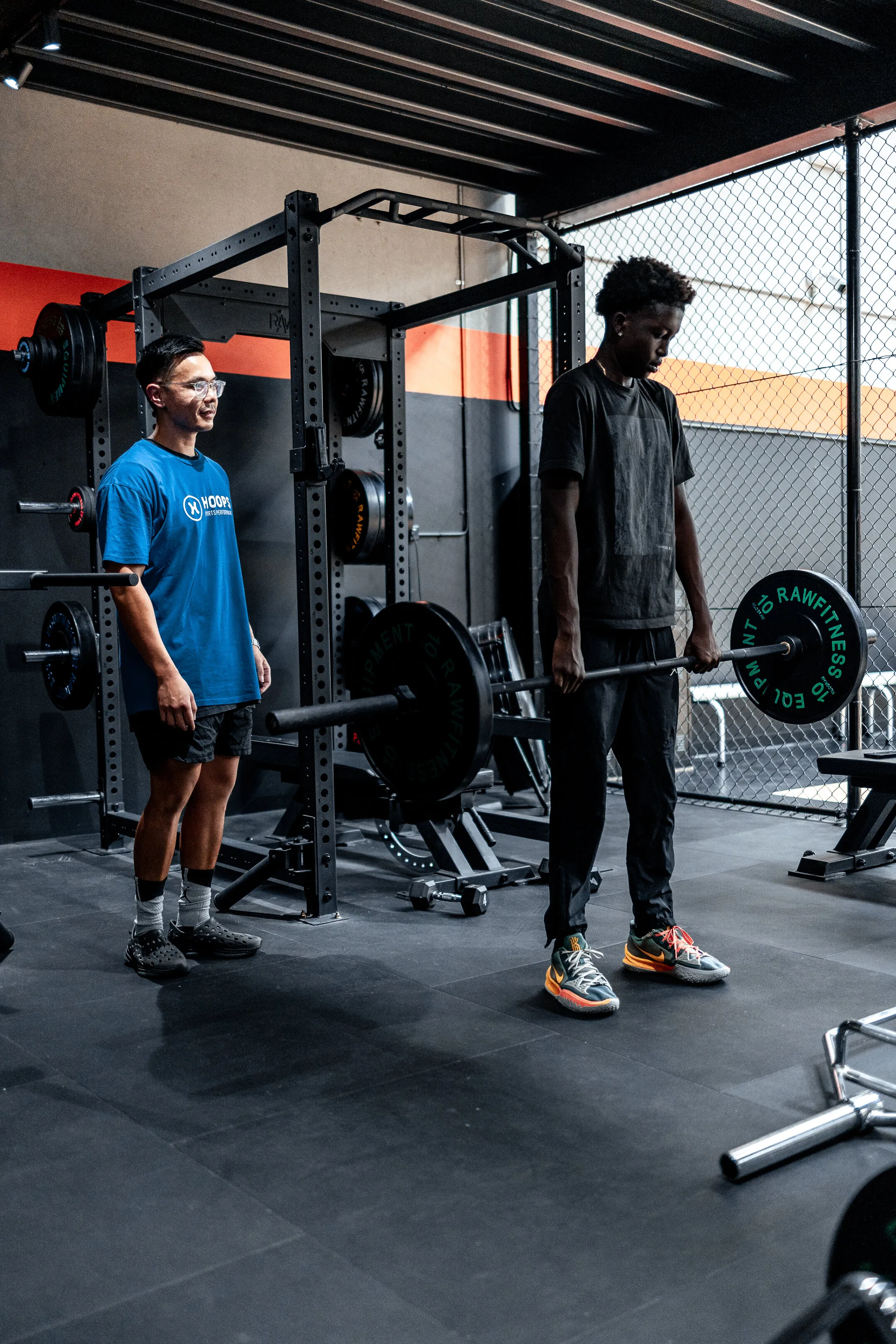 a man standing next to another man in a gym