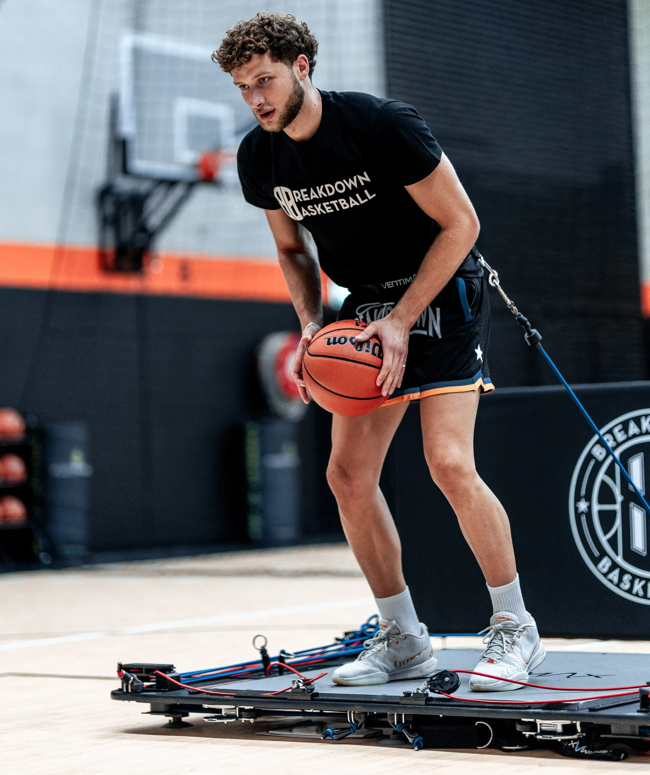 a man holding a basketball while standing on a basketball court