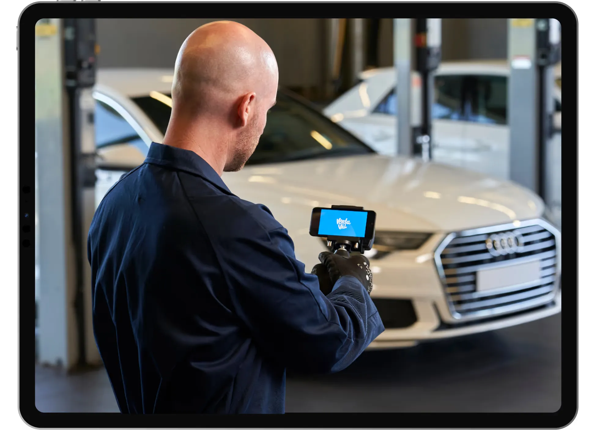 Technician filming a car on the ramp for a video inspection