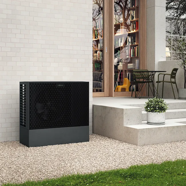 Moderne Luft-Wasser-Wärmepumpe neben Terrasse eines Einfamilienhauses – effiziente Heizlösung für nachhaltiges Wohnen.