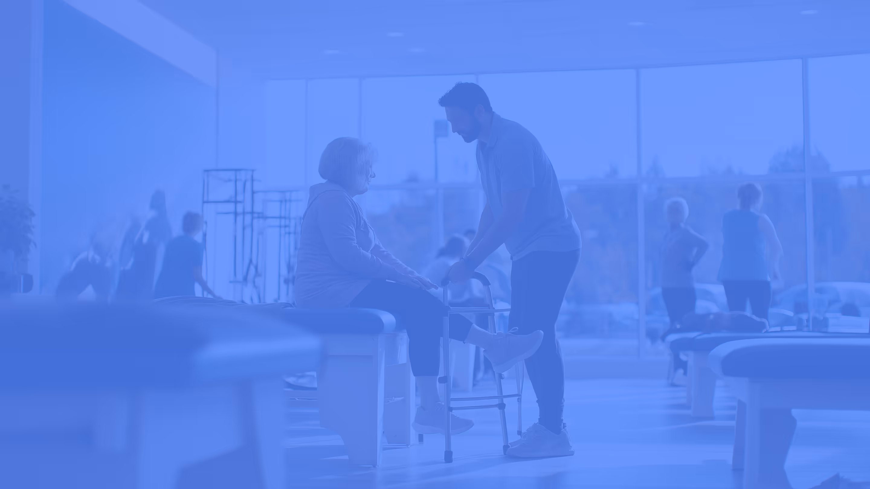 Physical Therapy clinic with practitioner and patient center in the aisle