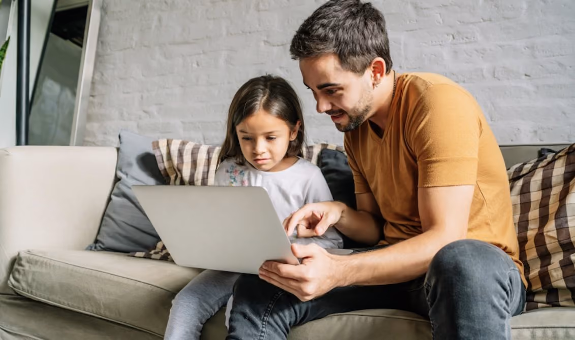 Un papá y su hija usando una computadora