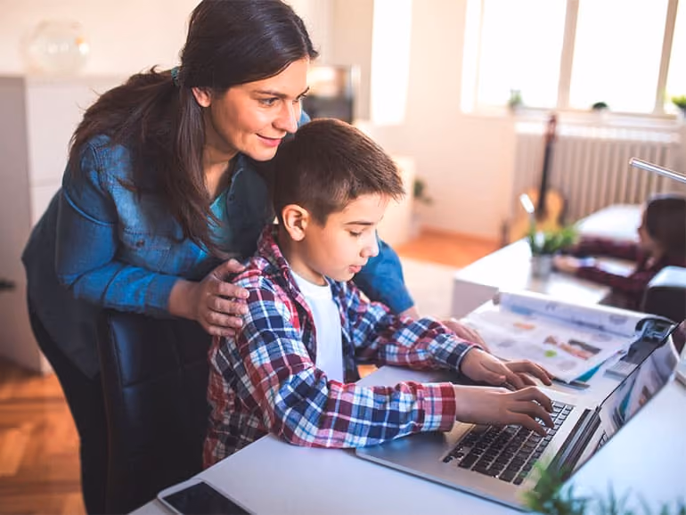 Una mamá acompañando a su hijo mientras estudia 
