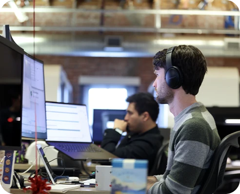A photo of two engineers sitting at their desks.