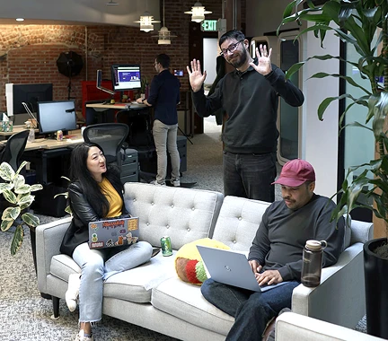 People sitting on a couch waving