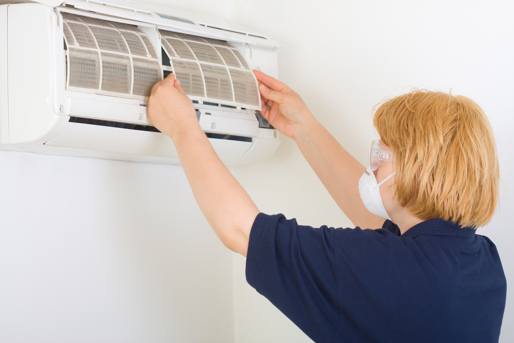 A homeowner cleans AC filters for optimal performance.