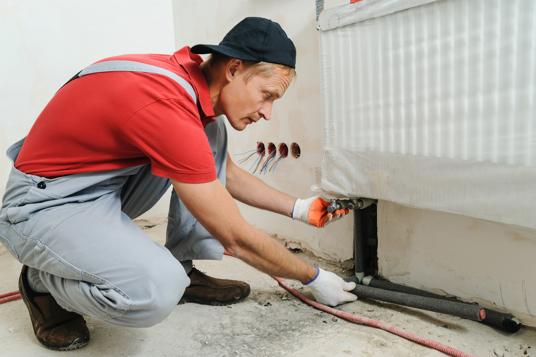 A heating contractor attaches the pipe to the radiator during the heating installation.