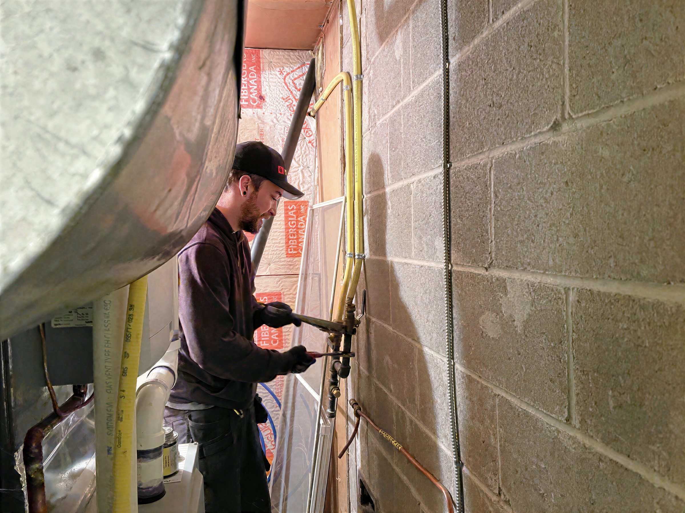 Matrix Mechanical gas technician connecting gas piping and shut-off valve in a basement