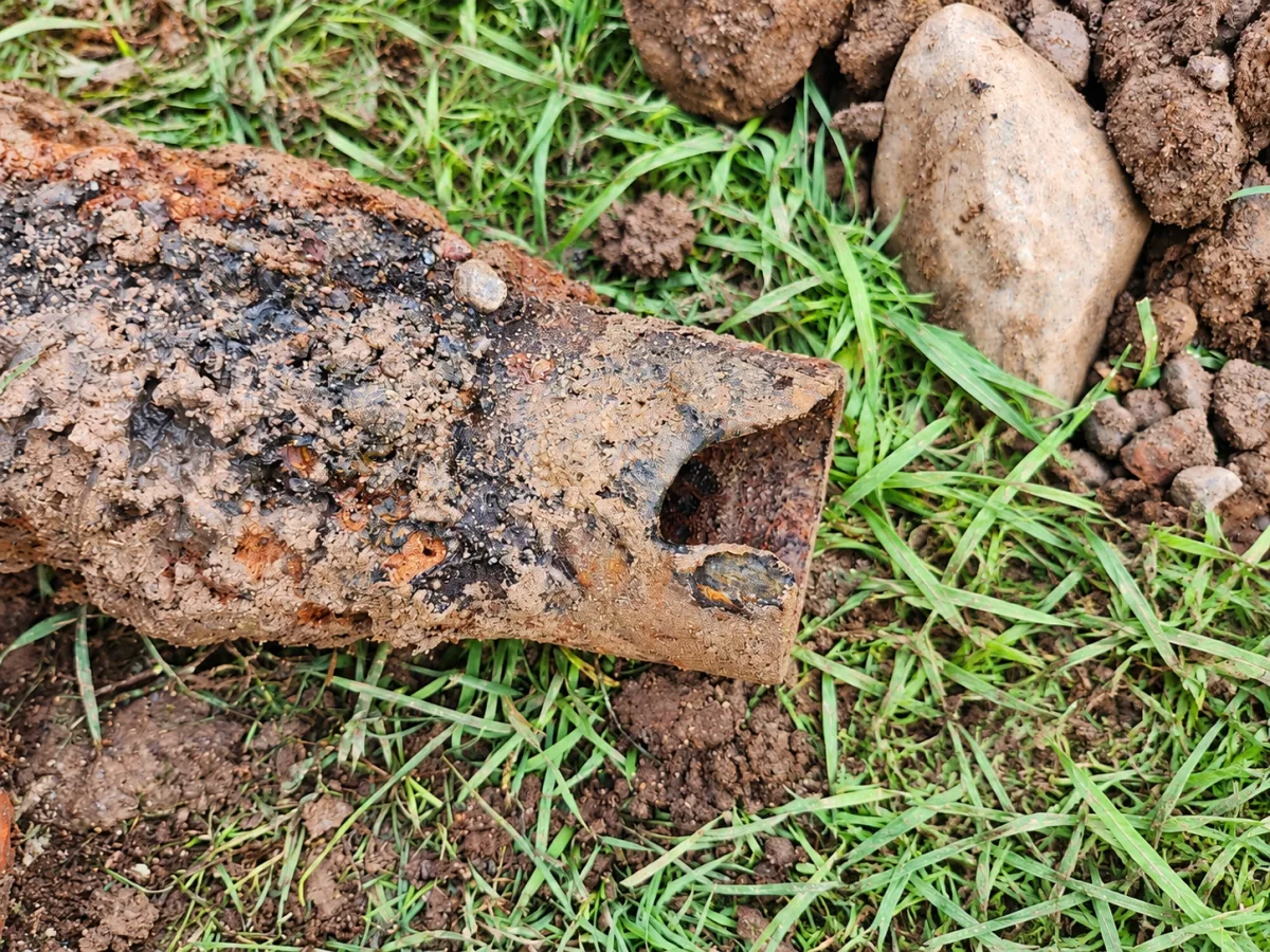 Removed cast-iron sewer pipe with visible corrosion and missing material.