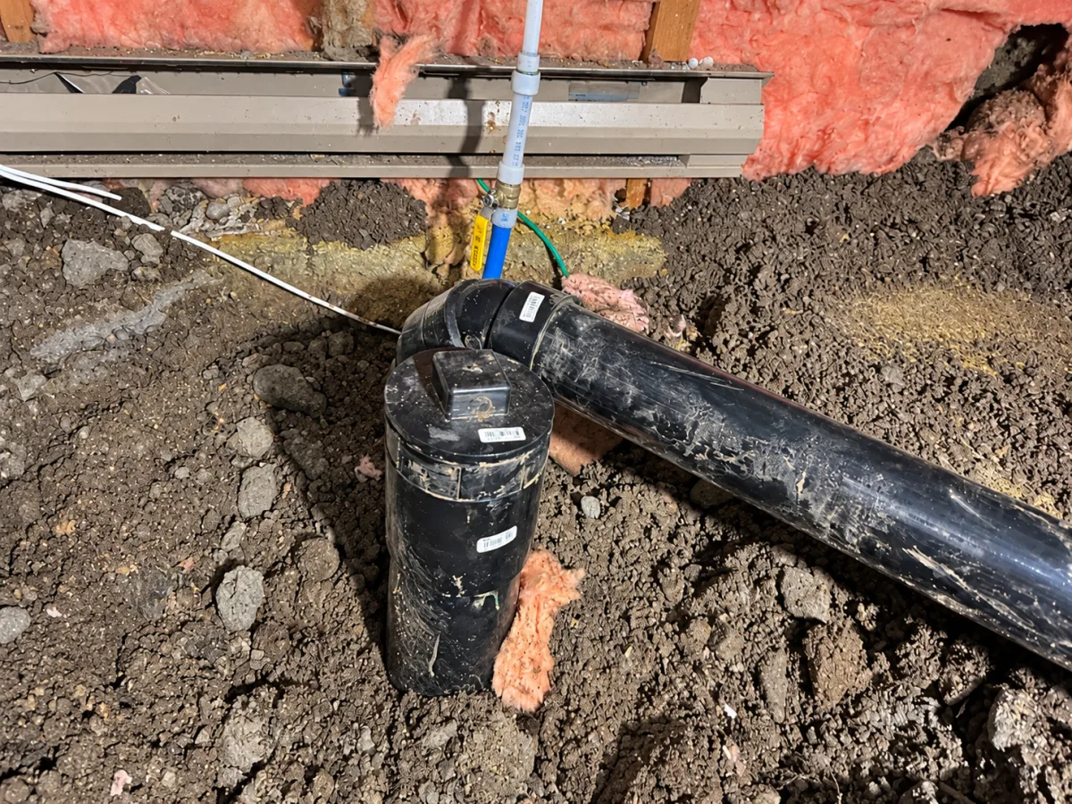 Replacement drain junction and water-service connection in the crawl space.