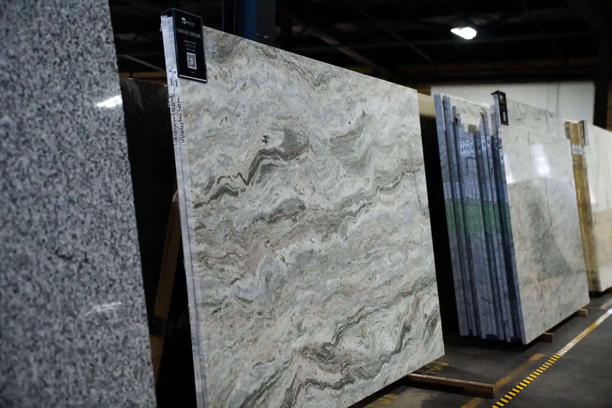 Full quartz slabs with natural movement displayed in a premium stone showroom for designer selection
