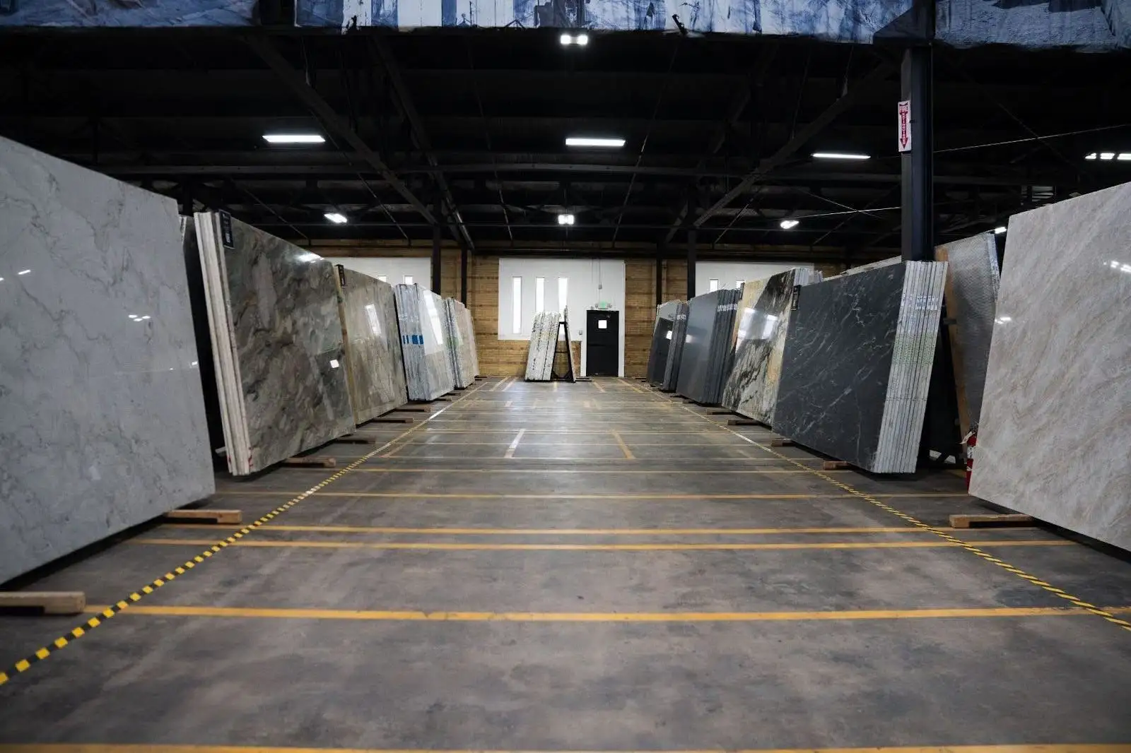 Rows of full-size quartz and stone slabs displayed in a spacious showroom selection area
