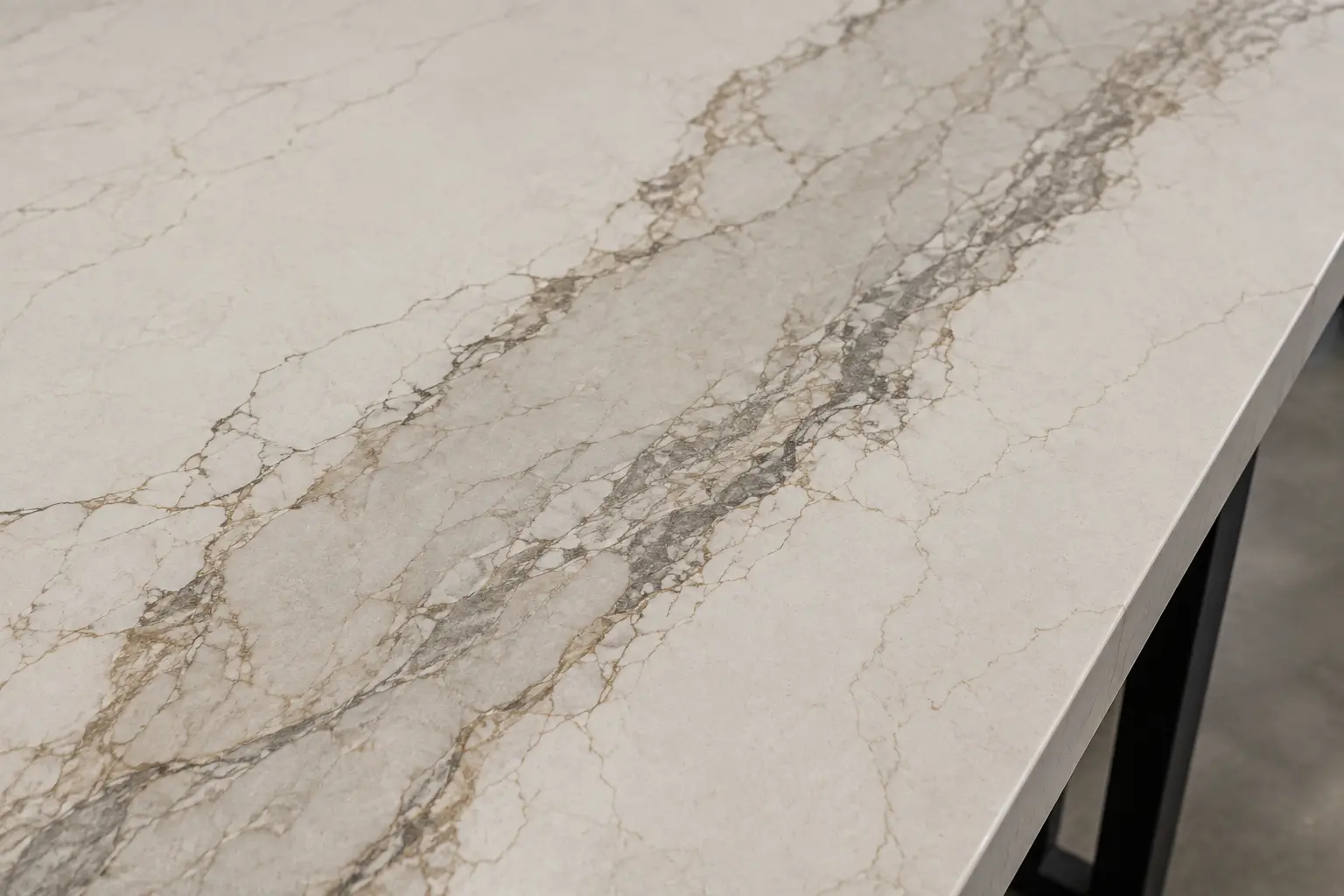 Close-up of quartz with dramatic gray and warm veining showing movement to consider for a slab backsplash