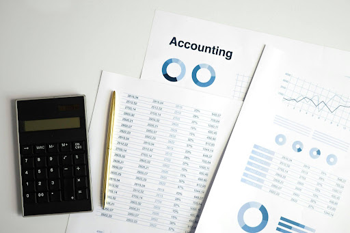 AI accounting dashboard with financial reports and a calculator on an office desk