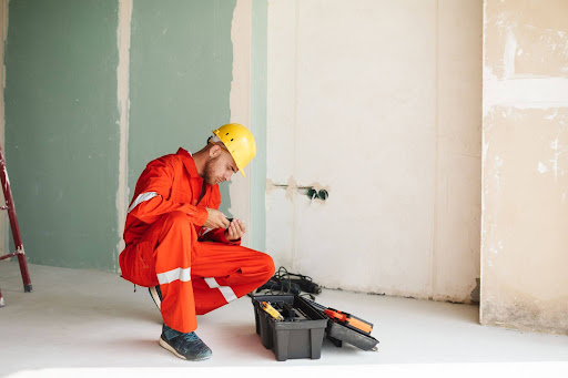 Emergency restoration contractor preparing tools inside damaged property during active repair work.