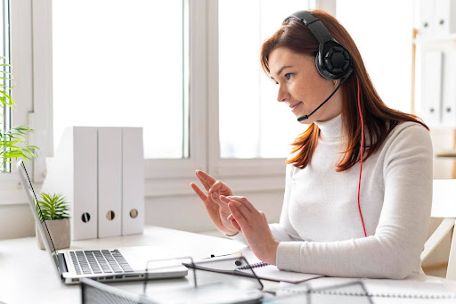 Support agent using headset and laptop for AI answering and virtual receptionist services.'