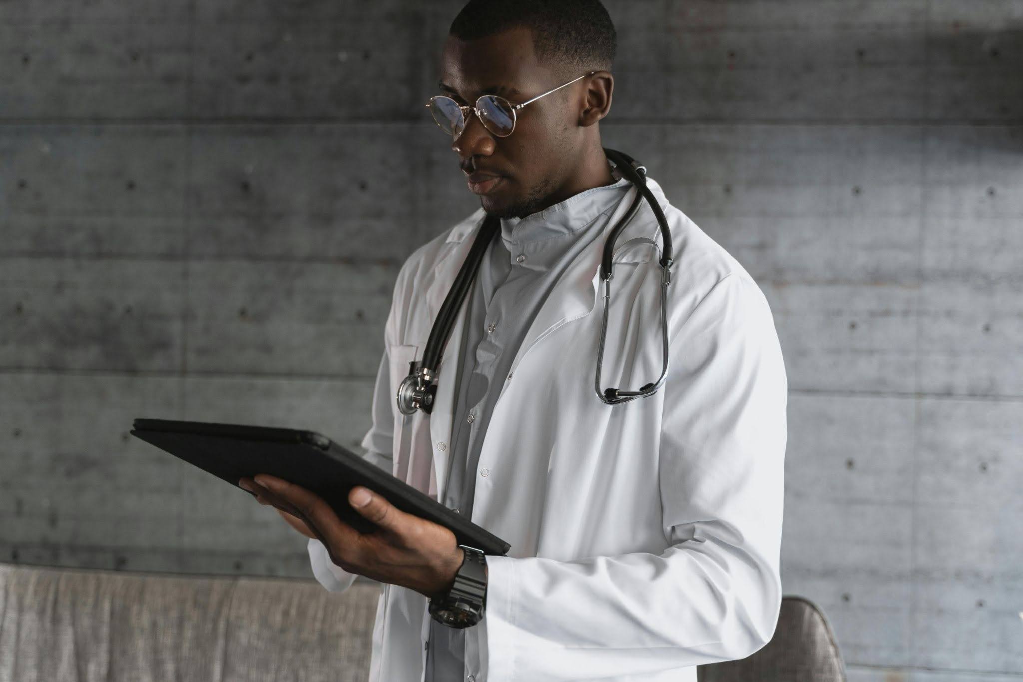 Doctor using AI-powered healthcare workflow technology on a tablet.