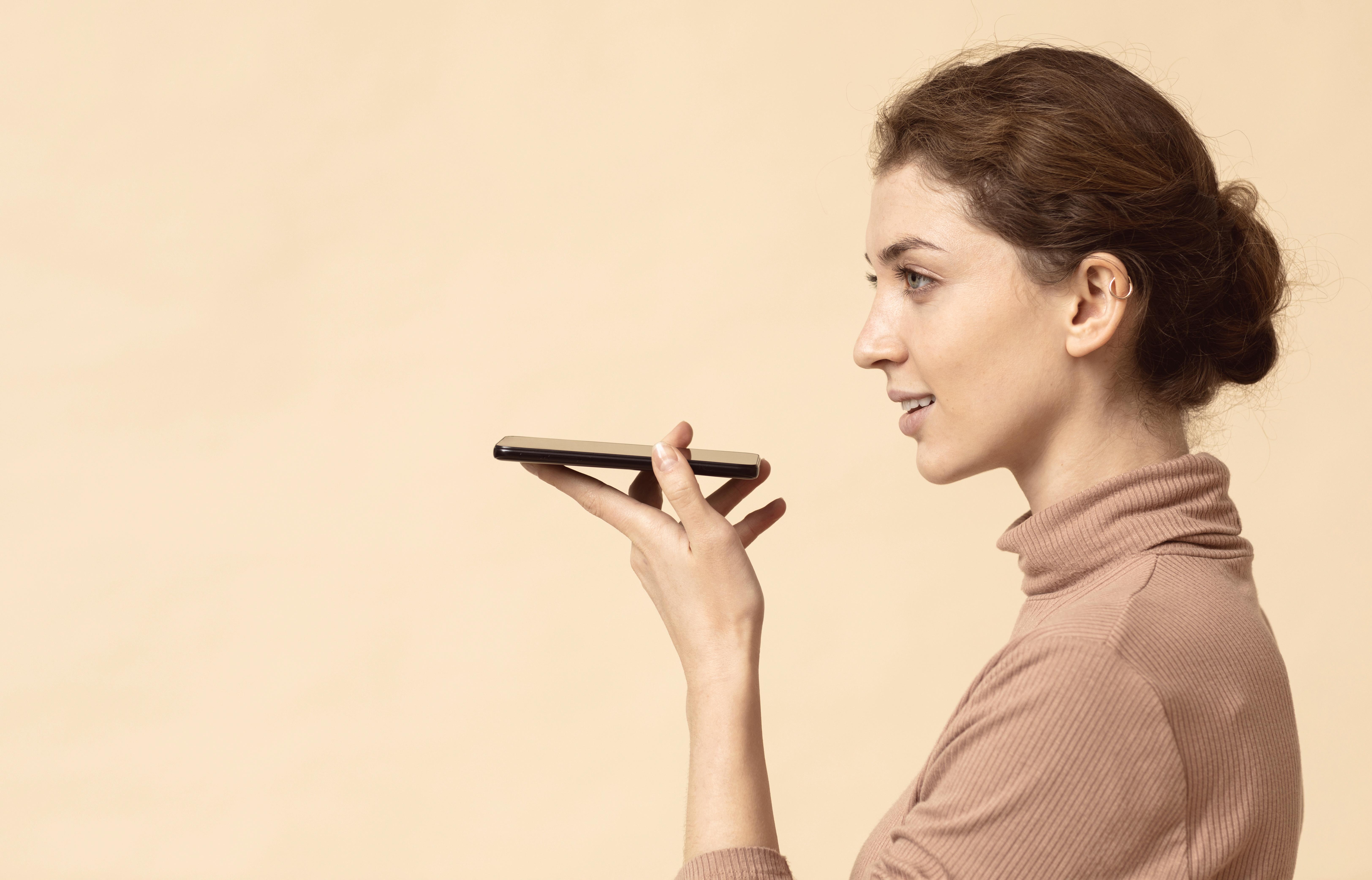 Woman using smartphone voice assistant
